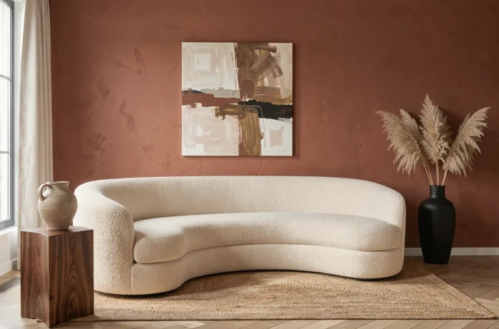 Salon moderne aux tendances déco 2024 avec canapé boucle crème, mur terracotta et vase céramique sculpté